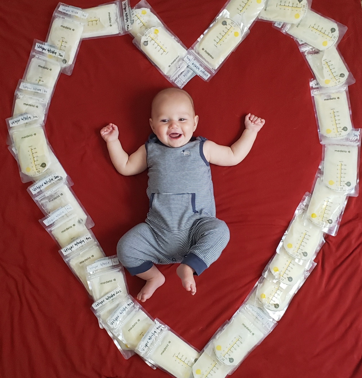 Happy baby surrounded by donated breast milk