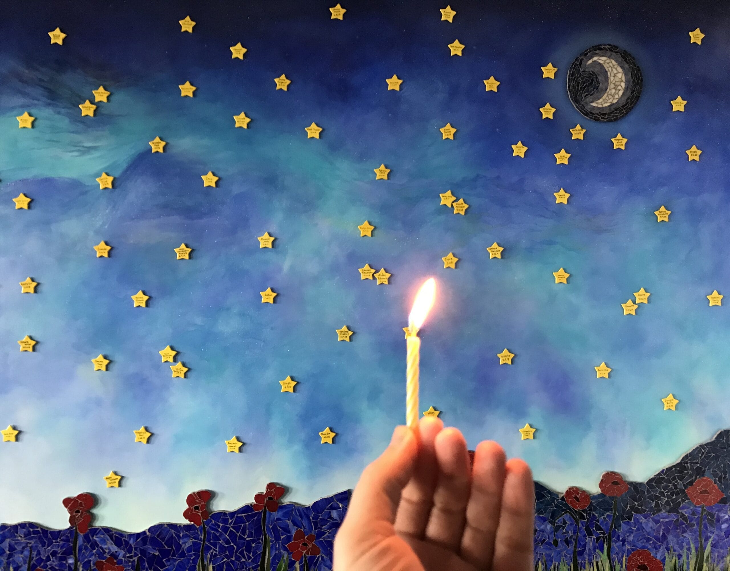 Hand with candle with a starry background