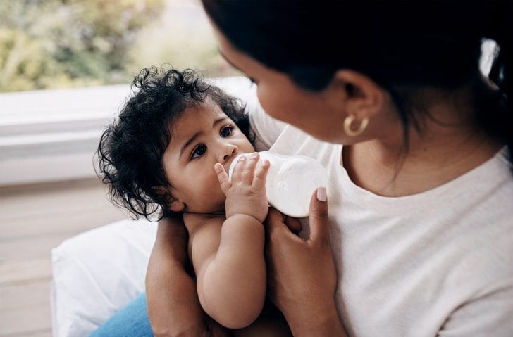 Mother giving her child a bottle of milk