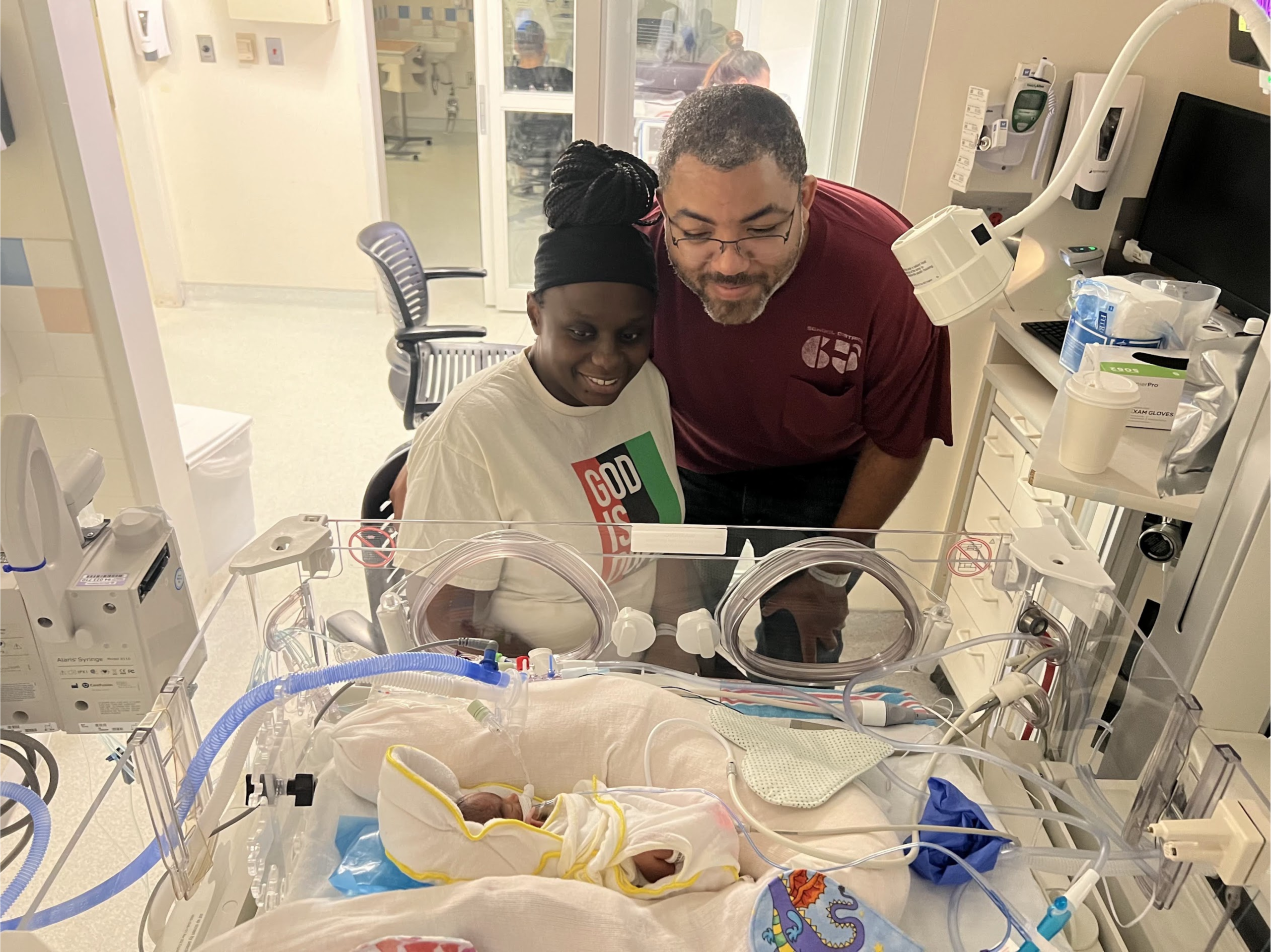 parents looking down at NICU baby